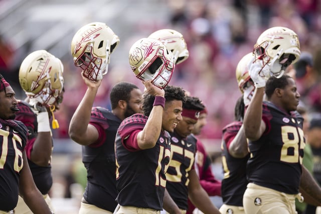 Jordan Travis #13 of the Florida State Seminoles holds up his helmet during warms up before the start of a game against the Louisiana-Lafayette Ragin Cajuns at Doak Campbell Stadium on November 19, 2022 in Tallahassee, Florida.