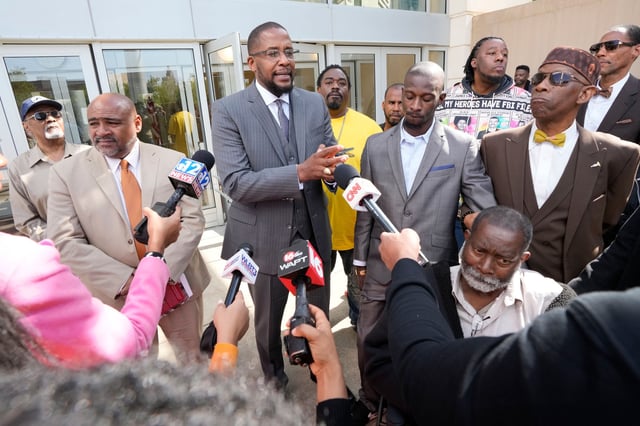Civil lead counsel Malik Shabazz, center, speaks to reporters following the sentencing of the fourth former Rankin County law enforcement officer, while his client Michael Corey Jenkins, right, listens while outside the federal courthouse in Jackson, Miss., Wednesday, March 20, 2024.