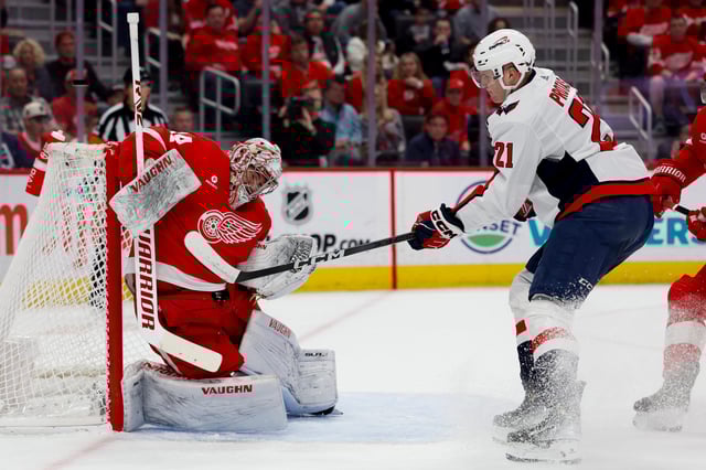 Red Wings goaltender Alex Lyon makes a save on Capitals center Aliaksei Protas in the first period on Tuesday, April 9, 2024, at Little Caesars Arena.