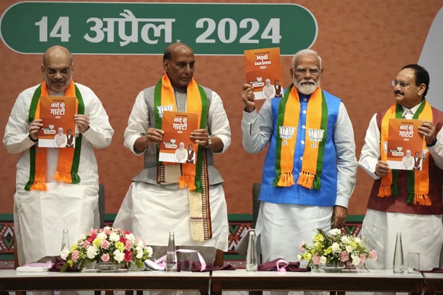 Indian Prime Minister Narendra Modi, second right, releases his ruling Bharatiya Janata Party's manifesto for the upcoming national parliamentary elections in New Delhi, India, Sunday, April 14, 2024. Standing from L to R with him are BJP's senior leaders Home Minister Amit Shah, Defence Minister Rajnath Singh and Party President JP Nadda. (AP Photo/Manish Swarup)