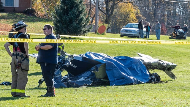 Emergency personnel wait for the coroner after a fatal small plane crash in a yard at Dorance Farm in Hanover Township, Pa., on Oct. 29, 2022.