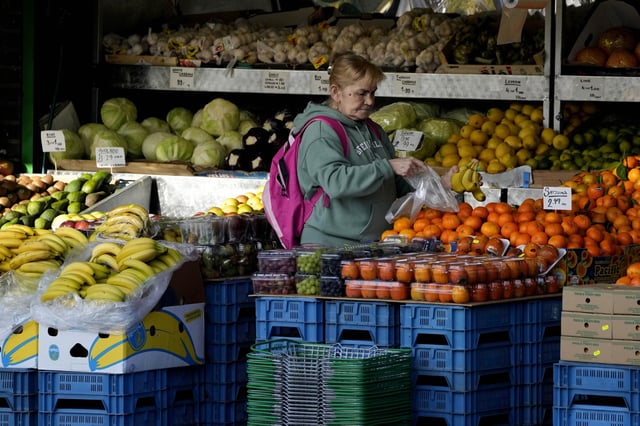 A woman selects fruits at a supermarket in London, on Nov. 17, 2021. Inflation in the U.K. fell to its lowest level in two and a half years in March after a further easing in food prices, official figures showed Wednesday, April 17, 2024. (AP Photo/Frank Augstein, File)
