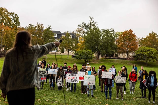 Protesters chant in support of sexual assault survivors during a rally at Indiana University.