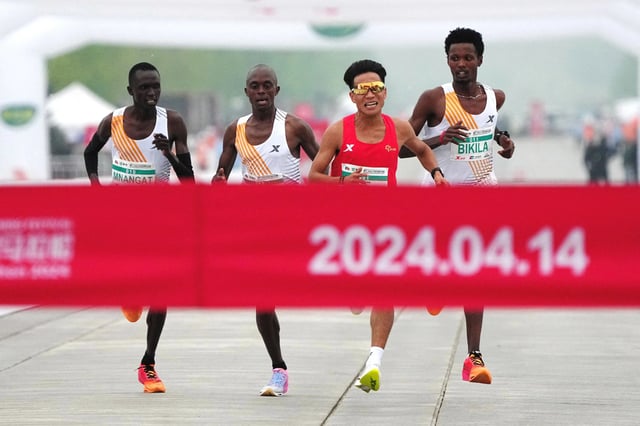 Chinese runner He Jie, Ethiopian Dejene Hailu Bikila and Kenyans Robert Keter and Willy Mnangat approach the finish line in a half-marathon in Beijing on April 14, 2024. 