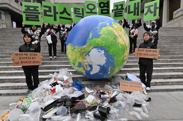 April 22, 2024: Environmental activists hold up placards reading "Let's end plastic pollution!" as they display plastic waste with an earth balloon during a campaign event to mark the international Earth Day in Seoul.