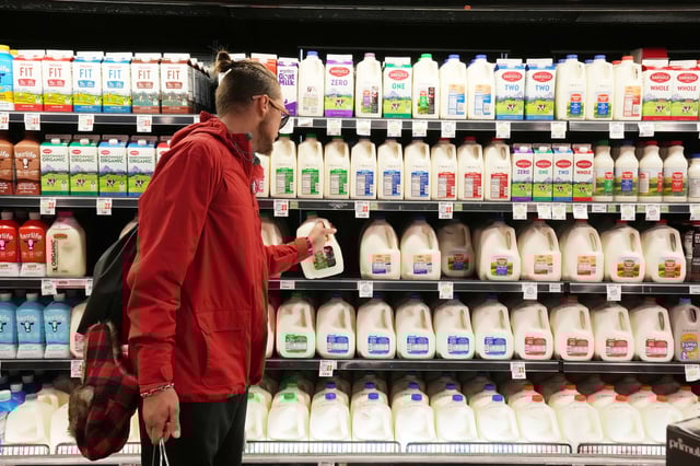 A customer takes a gallon of milk from a  store shelf in Salt Lake City,