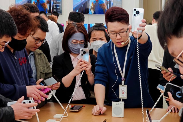 People try out Huawei’s Pura 70 series smartphones at a store in Shanghai. Photo: AFP