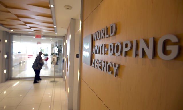 A woman walks into the head office for the World Anti-Doping Agency (WADA) in Montreal, November 9, 2015. An international anti-doping commission recommended on Monday that Russia's Athletics Federation be banned from international competition over widespread doping offences - a move that could see the powerhouse Russian team excluded from next year's Rio Olympics. Russian sports minister said there was no evidence for the accusations against the Federation. REUTERS/Christinne Muschi       TPX IMAGES OF THE DAY
