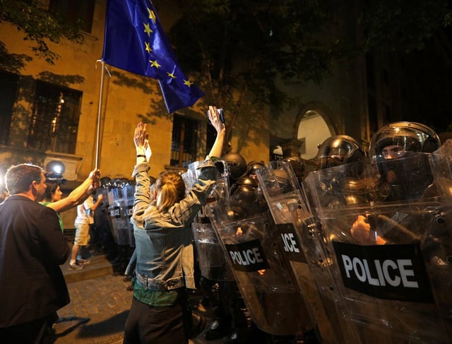 A demonstrator raises her hands in front of riot police during a protest in Tbilisi, Georgia on Sunday. Photo: Reuters