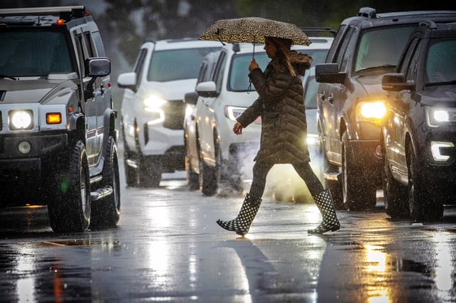 A pedestrian crosses the road during heavy rain in La Verne, Calif., on Feb. 20, 2024.