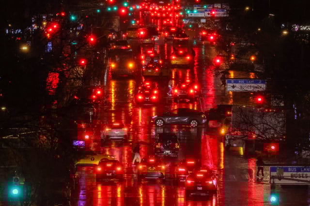 Pedestrians and cars move along First Avenue in the Manhattan borough of New York, in the pouring rain, on February 27, 2024. (Photo by Charly TRIBALLEAU / AFP)