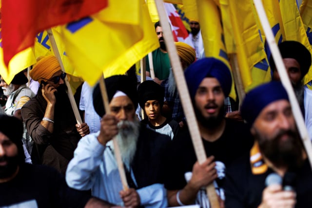 People hold flags during a Sikh rally outside the Indian consulate  in Toronto on Sept. 25, 2023.