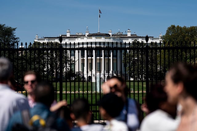 People pass outside of the White House in Washington, DC on April 14, 2024.