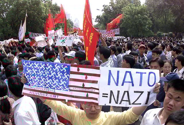 A protester holds up a makeshift American flag and shouts anti-US slogans as thousands of angry Chinese march to the US embassy in Beijing on 09 May 1999. Angry demonstrators among an estimated 20,000-strong crowd threw rocks and water bottles at the US and British embassies, breaking window in protest at Nato’s bombing of the Chinese embassy in Belgrade. Photo: Agence France-Presse