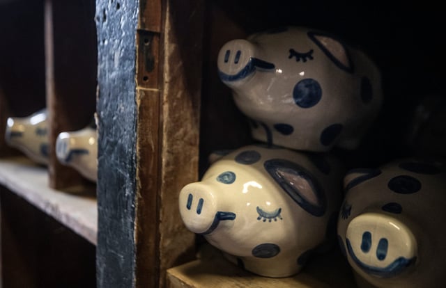 Several piggy banks sit on stock room shelves at Hadley Pottery in Louisville, Kentucky on April 1, 2022.