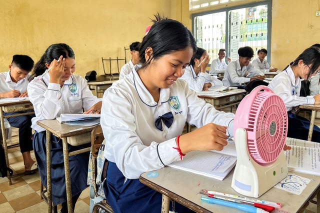 Student Lim Sokha, 15, uses a fan to cool down during her class in Phnom Penh, Cambodia, on May 2, 2024.