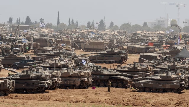 Israeli soldiers with military vehicles gather at an undisclosed position near the border fence with the Gaza Strip, in southern Israel on Thursday. Photo: EPA-EFE