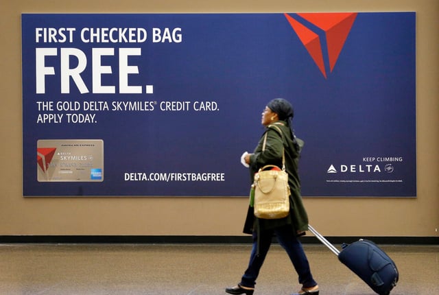 A Delta Air Lines credit card advertisement at Seattle-Tacoma International Airport.