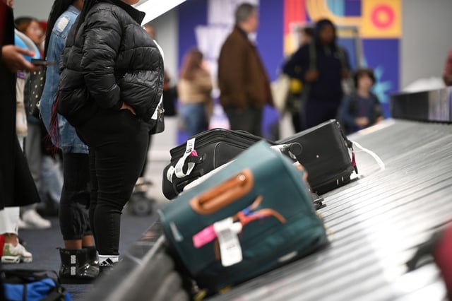 Passengers wait for the their luggage at the arrival terminal inside LaGuardia Airport terminal B in Queens, New York, on Dec. 29, 2022.
