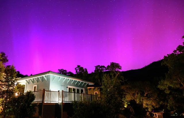 Northern lights or aurora borealis illuminate the night sky over a camper's tent north of San Francisco in Middletown on May 11, 2024. The most powerful solar storm in more than two decades struck Earth, triggering spectacular celestial light shows from Tasmania to Britain — and threatening possible disruptions to satellites and power grids as it persists into the weekend.