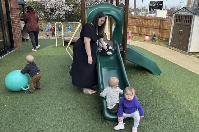 Delaney Griffin plays with toddlers at the child care center where she works, March 13, 2024, in Lexington, Kentucky. The state started a program in 2023 that offers free or reduced-cost care to child care workers. Ms. Griffin chose her job because of the program. 
