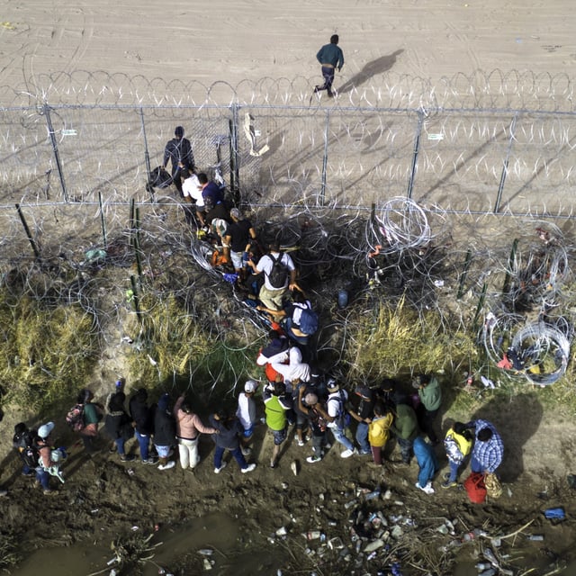 In an aerial view, immigrants pass through coils of razor wire while crossing the U.S.-Mexico border on March 13, 2024 in El Paso, Texas. New internal data from U.S. Customs and Border Patrol shows that there are fewer "got-aways" than initially estimated by federal agencies.