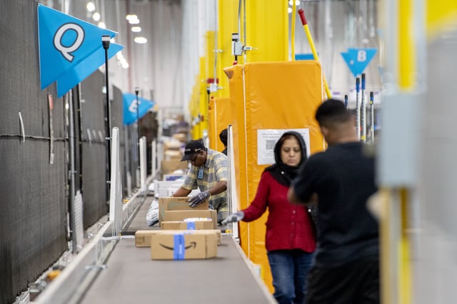 Workers fulfill orders at an Amazon fulfillment center in Melville, New York, on July 11, 2023.