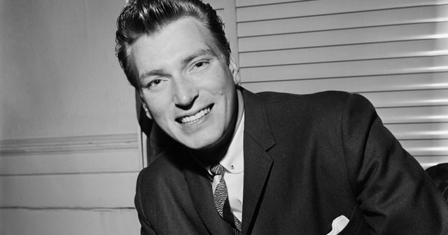 A black and white photo of Frank Ifield in 1959, wearing a suit