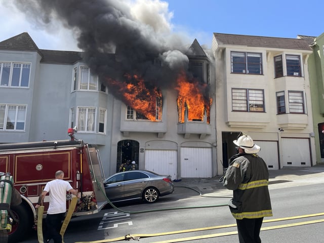San Francisco firefighters pulled two people from a burning residential building in Hayes Valley, one of whom sustained critical injuries. 