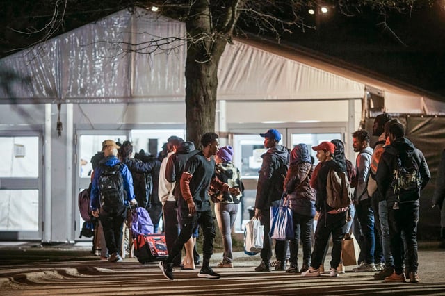 Migrants enter the migrant shelter on Randall's Island in New York on April 9, 2024.