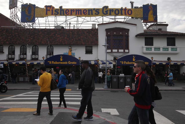 Pedestrians pass Fishermen’s Grotto in San Francisco in 2014. The restaurant was shuttered in 2020 and its owner is suing the city.