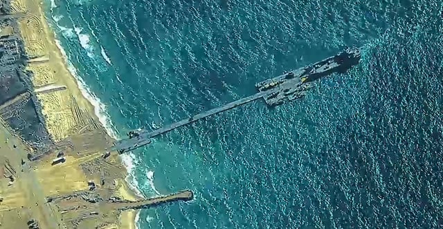 Looters steal Gaza aid delivered via a U.S.-built floating pier, raising concerns about aid to Palestinians and regional security. Pictured: This handout image shows U.S. soldiers and sailors working with Israeli troops May 16 to erect the temporary pier on the Gaza coast. (Photo: U.S. Central Command/ Getty Images)
