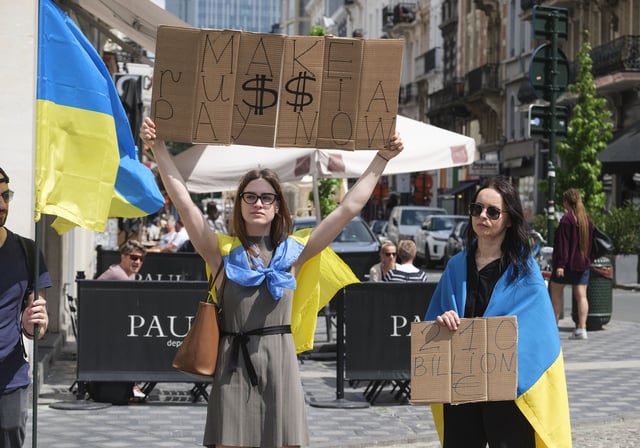 BRUSSELS, BELGIUM - MAY 13: 2 Ukrainian women holds panels during a demonstration organised by Promote Ukraine International Center for Ukrainian Victory (ICUV) near the Belgium Parliament on May 13, 2024 in Brussels, Belgium. Promote Ukraine asserts that the Russian Central Bank holds approximately $210 billion within the EU, primarily in Belgium. The organization believes, "these funds are most rightful to use for strengthening Ukraine's air defense without prolongation." (Photo by Thierry Monasse/Getty Images)