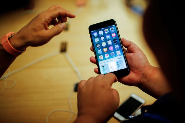 Customers take a look of the new iPhone 7 smartphone inside the Apple Inc. store in New York, U.S., September 16, 2016.