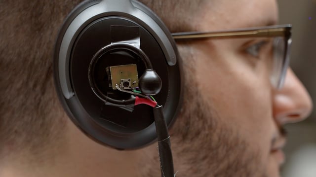 A University of Washington team has developed an artificial intelligence system that lets a user wearing headphones look at a person speaking for three to five seconds and then hear just the enrolled speaker’s voice in real time even as the listener moves around in noisy places and no longer faces the speaker. Pictured is a prototype of the headphone system: binaural microphones attached to off-the-shelf noise canceling headphones.