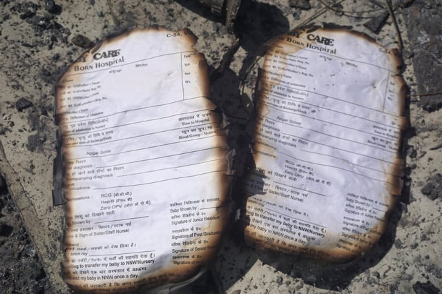 Burnt registration cards lie on the floor of a baby care centre in New Delhi after fire broke out on Saturday night, killing six infants. Photo: AP
