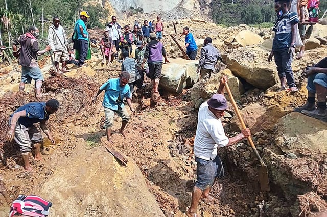 Residents dig at the site of a landslide at Yambali Village in Papua New Guinea's Enga Province on May 26, 2024.