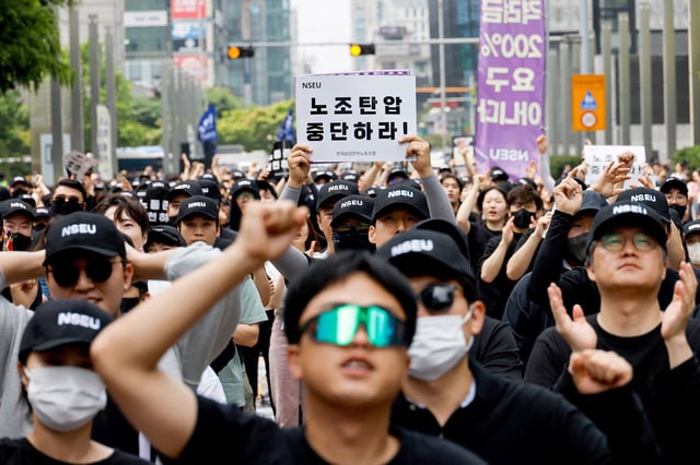 A union holds a placard that says "stop union busting" in front of the Samsung Electronics Seocho Building in Seoul on May 24, 2024.
