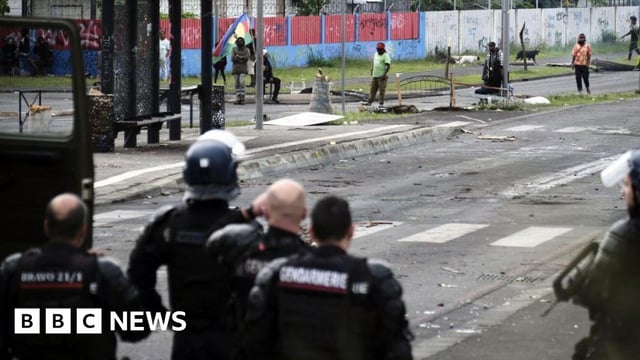 French gendarmes stand guard near independantists at the entrance of the Riviere Salee disctrict, in Noumea, France's Pacific territory of New Caledonia, on May 29, 2024