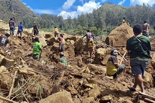 Locals dig at the site of a landslide at Yambali village, Papua New Guinea, on May 29, 2024.
