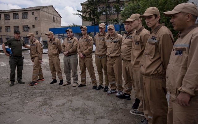 Inmates line up in the yard of a prison colony in the Kyiv region, Ukraine. The prisoners are part of a government scheme to recruit some convicts for the military. Photo: Reuters