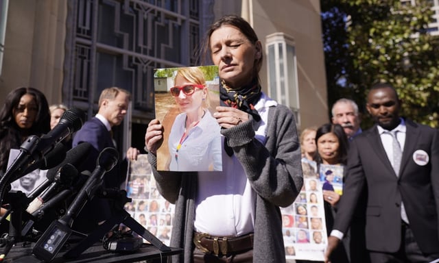 Catherine Berthet, of France, closes her eyes as she holds a photo of her deceased daughter Camille Geoffroy, in front of other families that lost loved ones to crashes of the Boeing 737 Max airliner outside the federal court in Fort Worth, Texas, Thursday, Jan. 26, 2023. Relatives of passengers who died in two Boeing Max crashes are pushing federal officials to prosecute the company, but they're not getting any promises from the Justice Department.(AP Photo/LM Otero, file)