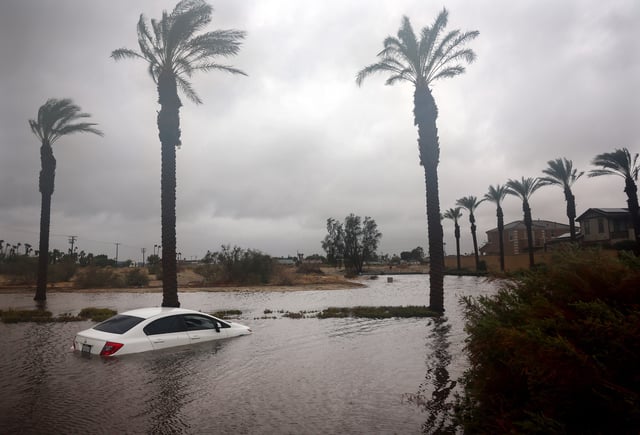 A car is partially submerged in floodwaters as Tropical Storm Hilary moved through the area on August 20, 2023 in Cathedral City, California.