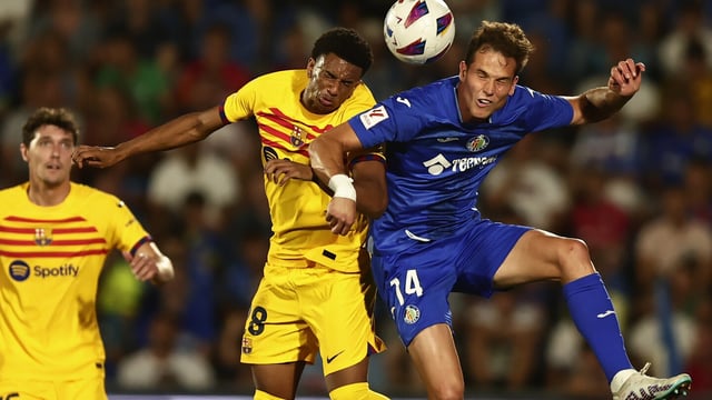 Getafe's Juanmi Latasa, right, and Barcelona's Alejandro Balde challenge for the ball during the Spanish La Liga soccer match between Getafe and FC Barcelona at the Coliseum Alfonso Perez stadium in Getafe, Spain, Sunday, Aug. 13, 2023. (AP Photo/Alvaro Medranda)