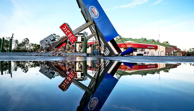 A storm-damaged gas station is reflected in a puddle after Hurricane Idalia crossed the state on August 30, 2023 in Perry, Florida. The storm made landfall at Keaton Beach, Florida as a category 3 hurricane. (Credit: Sean Rayford/Getty Images)