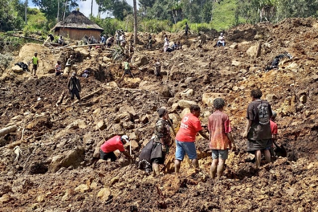 Locals dig during search and rescue efforts at the site of a landslide in Papua New Guinea late last month
