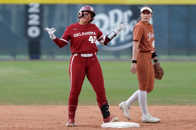 Oklahoma's Alynah Torres (40) gestures next to Texas' Leighann Goode (43) after reaching second base during the Big 12 Tournament championship game on May 11, 2024.