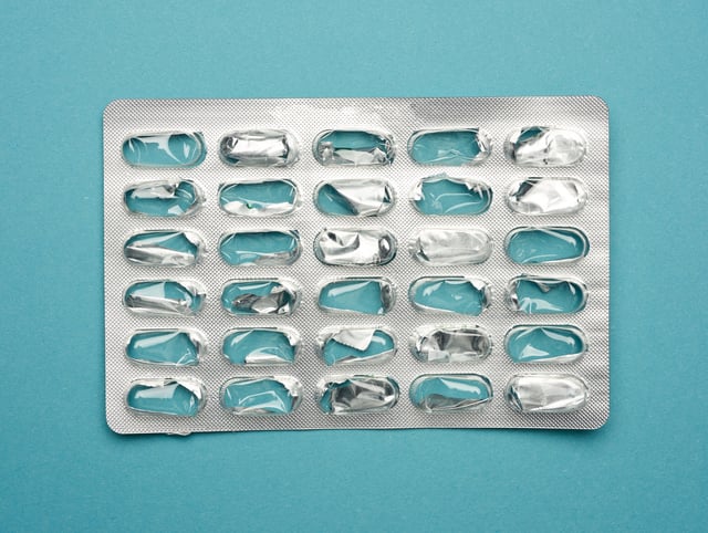 blank blister pack of capsule pills on a blue background, top view