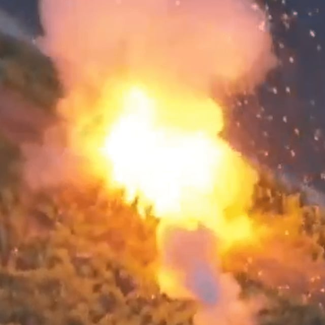 A screenshot of footage published by Ukraine's government, appearing to show the moment a Ukrainian explosive drone drops into a Russian tank fitted with protective armor designed to fend off Kyiv's uncrewed aerial vehicles (UAVs). "Turtle tanks" have been popping up along the frontlines, videos published in recent months suggest.