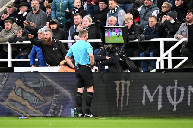 Referee Sam Barrott checks the pitch-side video assistant referee screen to review a yellow card given to Raúl Jiménez of Fulham during the Premier League match against Newcastle United on December 16, 2023.